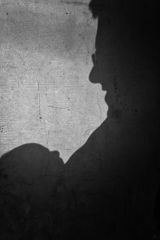 Silhouette of a father and child on a pale wall